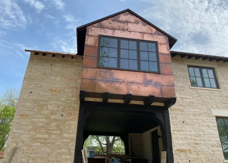Copper metal panel facade on a stone building for Roof Repair in Bettendorf