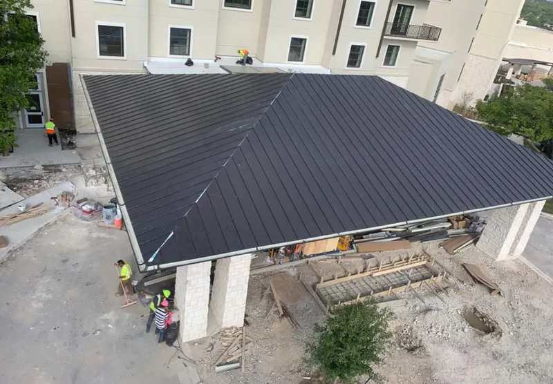 Metal roofing installation team working on a commercial building in Bettendorf